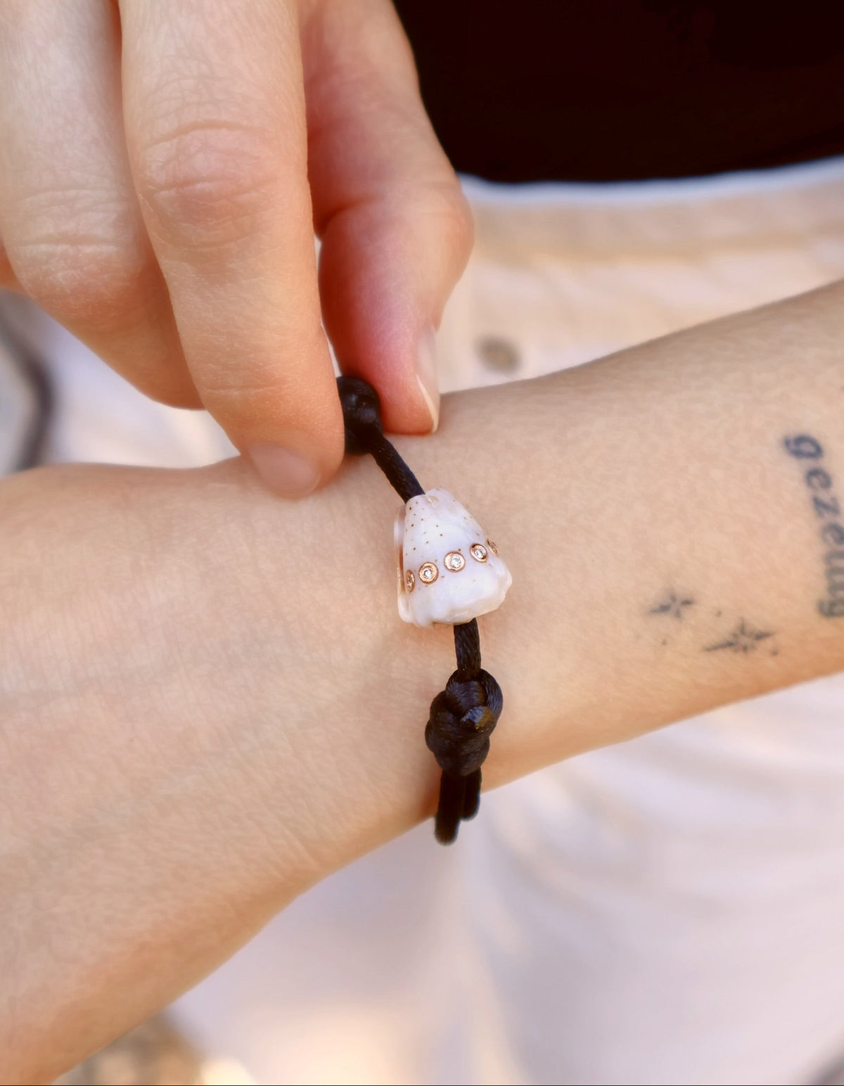 18k rose gold petite diamond conus white shell bracelet with adjustable black cord by Dezso Tiny Gods