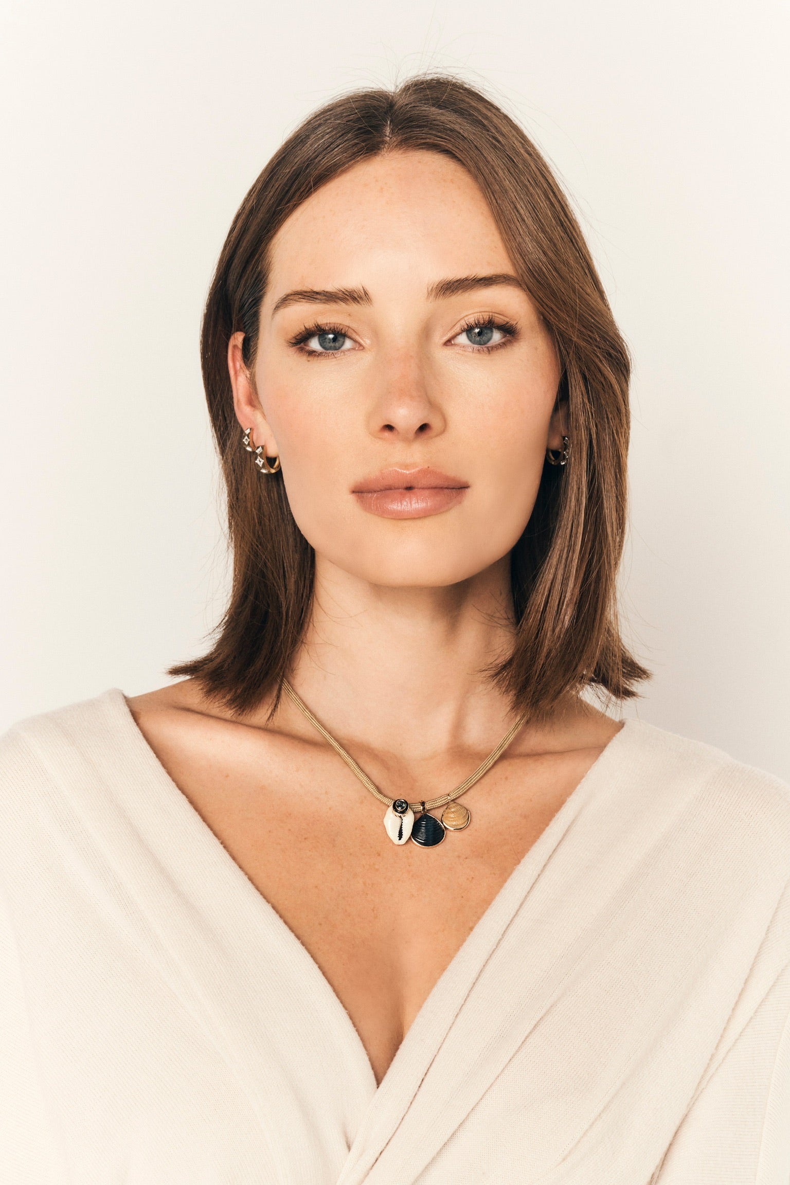 18k rose gold natural white Cory shell kyanite with blue tigers eye Venus shell and petite blond clam shell pendant by Dezso on taupe adjustable paracord Tiny Gods 