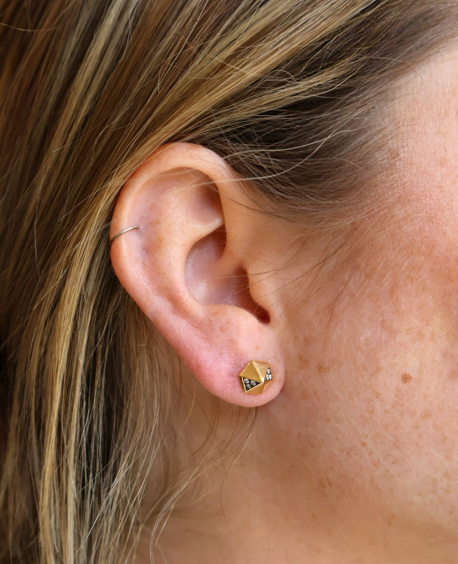 Pair of yellow gold pyramid stud earrings with rhodium and diamond details. 