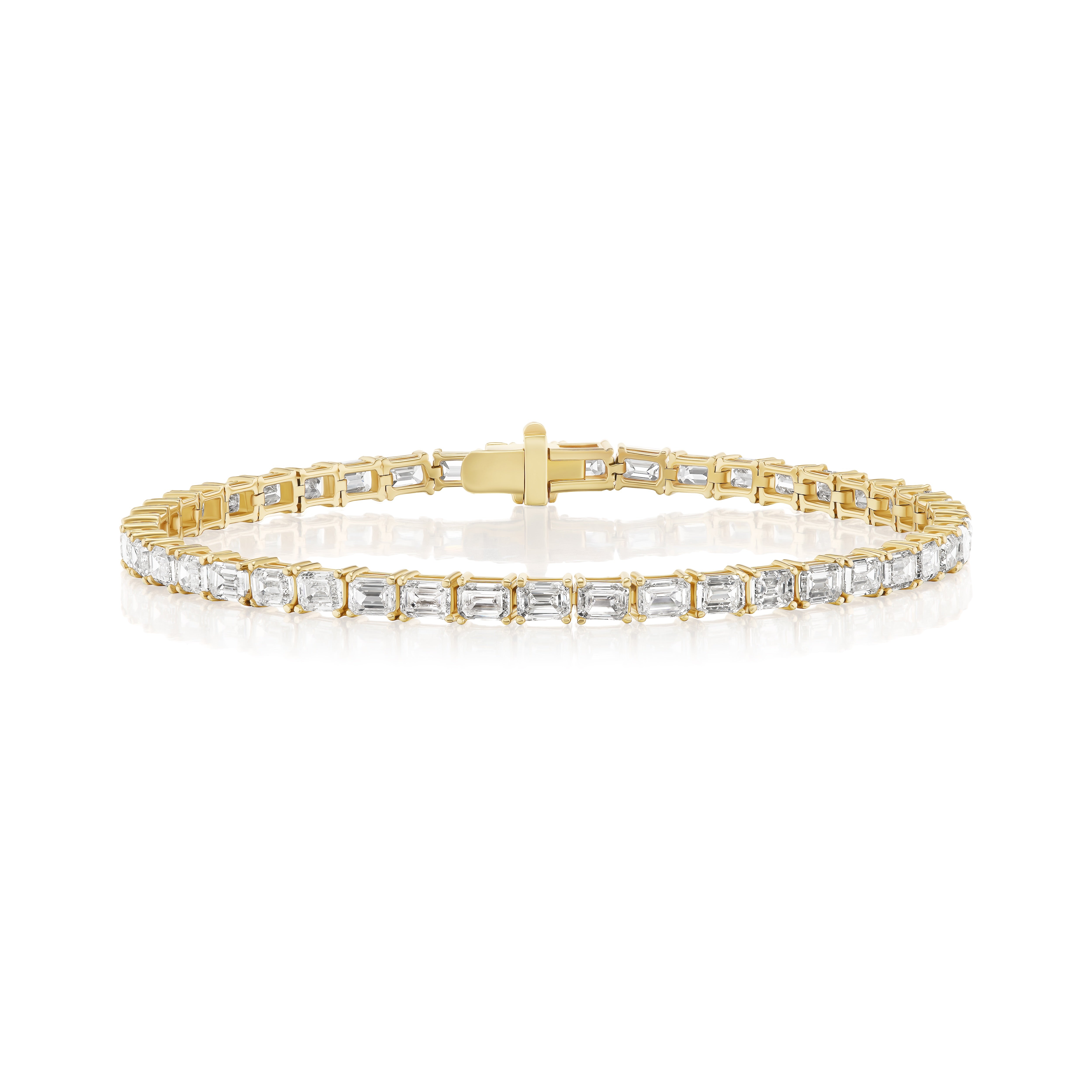 A yellow gold tennis bracelet featuring emerald cut diamonds. 