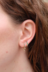 18k yellow gold otto earrings with emerald, diamonds and black rhodium detail by Sorellina Huggies on model Tiny Gods 