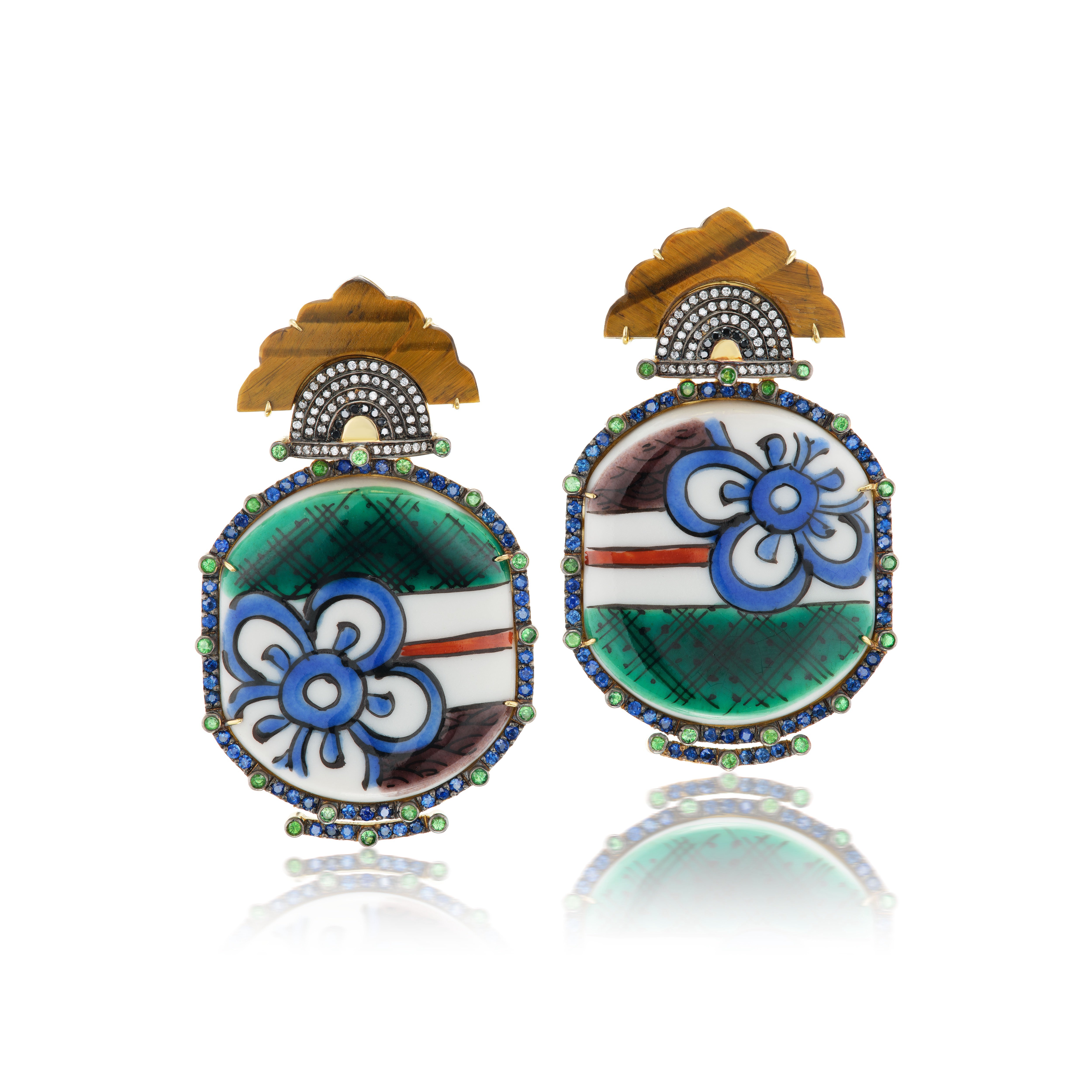 18k yellow gold hand painted blue flower ceramic earrings with blue sapphire and tsavorite border with black and white diamonds and carved tiger's eye earrings by Silvia Furmanovich Tiny Gods 
