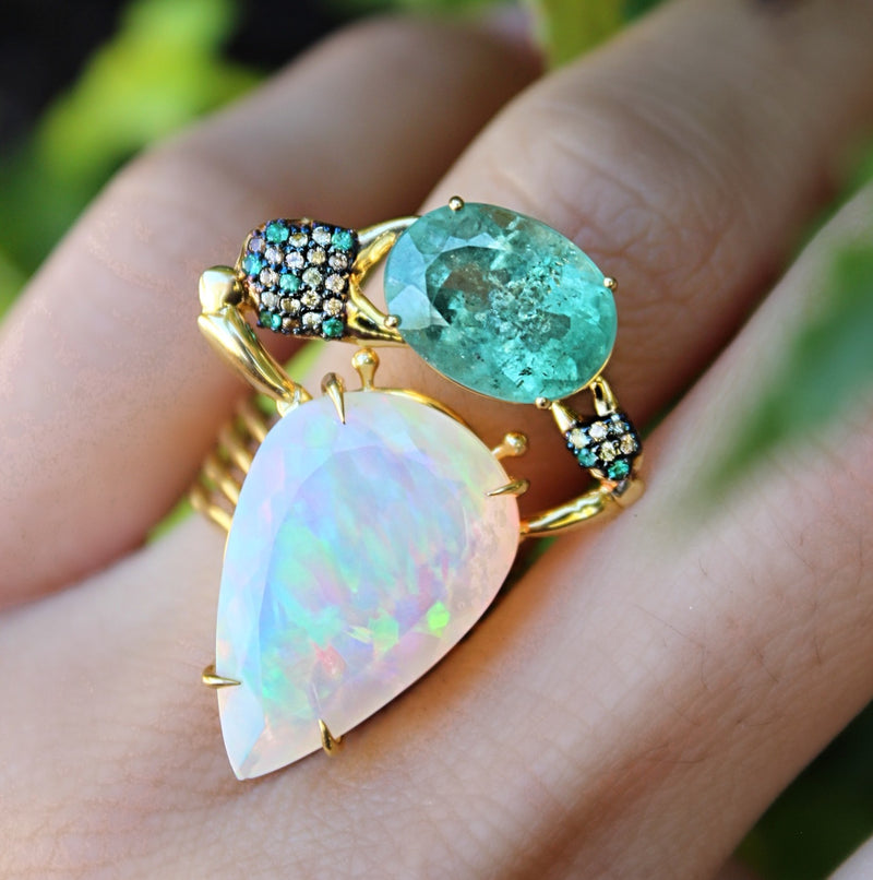 Named for one of the gods of rain and fertility, this opal and minty tourmaline ring is part of Daniela Villegas' Into the Deep Collection. 18K yellow gold Opal: 7.92cts Tourmaline: 4.83ct Green sapphires: 0.18cts Emeralds: 0.09cts One-of-a-kind Handmade in Los Angeles 